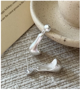 Macro shot of S925 sterling silver earrings with matte brushed texture on linen cloth