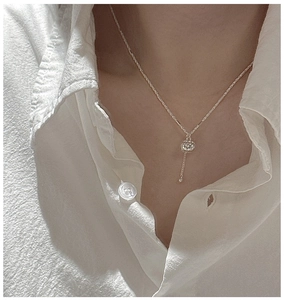S925 sterling silver necklace with ball pendant and tassel detail on female neck