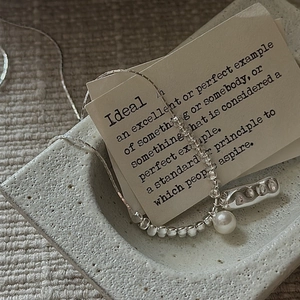 Minimalist S925 sterling silver necklace with pearl pendant on retro ceramic plate