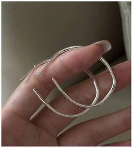 Macro detail of S925 sterling silver hoop earrings with irregular fluid texture finish