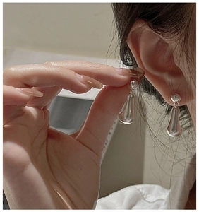 Detail of S925 sterling silver matte teardrop earrings shown being worn for size