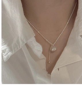 Close-up of S925 sterling silver persimmon pouch necklace with tassel on a female model
