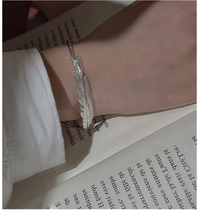 Detailed close-up of S925 sterling silver feather cuff bracelet with realistic textures