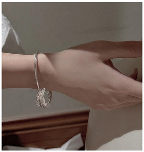 Detailed close-up of S925 sterling silver feather cuff bracelet with intricate engravings