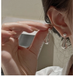 Detailed close-up of S925 sterling silver teardrop earrings on a model showing glossy finish