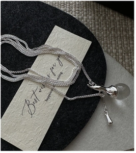 Detail of silver S925 multi-strand necklace with a liquid metal clear crystal pendant