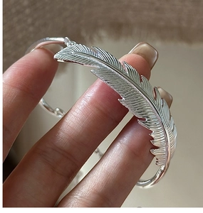 Macro shot of S925 sterling silver feather bracelet showcasing intricate realistic textures