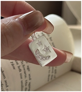 Detail of S925 sterling silver rectangular pendant with engraved star and moon crystals