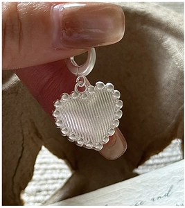 Macro view of S925 sterling silver heart pendant with vertical texture and bead edge