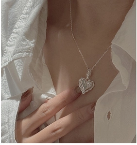 Close-up of S925 sterling silver heart pendant with layered wavy edges on a thin chain