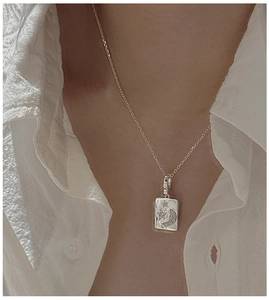 Close-up of S925 sterling silver rectangular necklace with moon and star pattern
