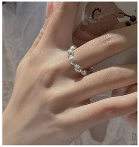 Macro shot of minimalist S925 sterling silver beaded ring on model hand with retro style