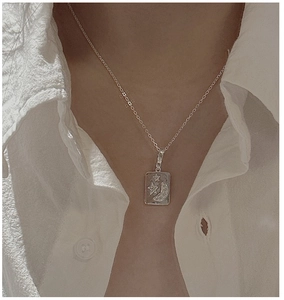 Detail of S925 sterling silver rectangular star and moon pendant necklace on a model