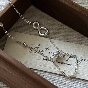 S925 sterling silver infinity bracelet with magnetic clasp on rustic wood background