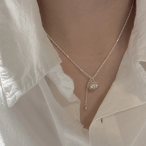 Elegant S925 sterling silver persimmon pouch necklace with tassel on a linen shirt