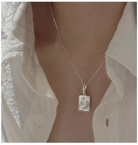 Close-up of S925 sterling silver vintage star and moon rectangle pendant on clavicle