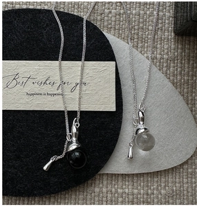 Detailed macro view of S925 silver necklace with spherical crystal and metal drop pendants