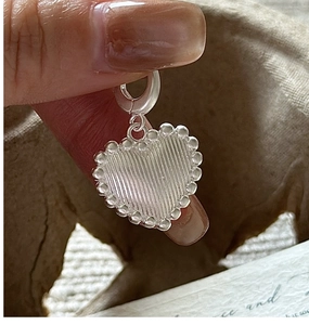 Detail of S925 sterling silver heart pendant with vintage texture and beaded edges