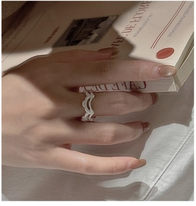 Detailansicht eines S925-Silberrings mit Vintage-Spitzentextur an einer Frauenhand