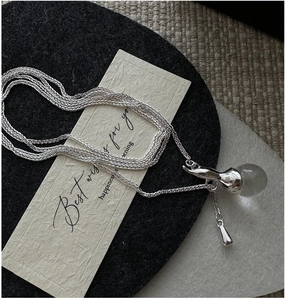 Macro view of S925 silver layered necklace featuring a clear crystal ball pendant