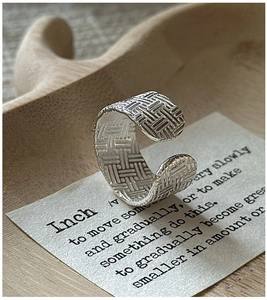 Macro d'une bague en argent 925 avec texture tissée vintage et gravure S925 de précision