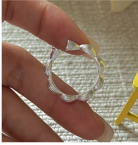 Macro detail of S925 sterling silver wavy open ring with brushed metal texture