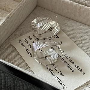 S925 sterling silver ribbon knot stud earrings with a minimalist textured finish