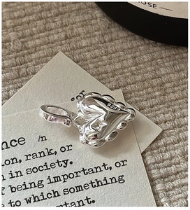 Macro shot of S925 sterling silver heart pendant with textured ripple finish and star detail