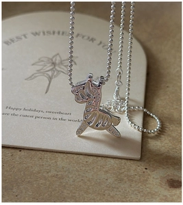 Macro shot of a S925 sterling silver donkey pendant necklace on a decorative gift card