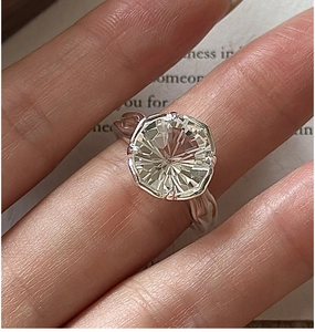 Detail of a 925 silver ring featuring a large round fireworks-cut white crystal gemstone