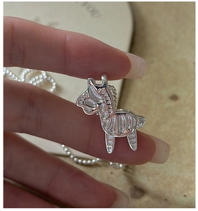 Close-up of S925 sterling silver zebra pendant with intricate engraved stripe details