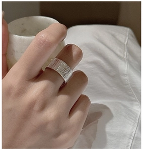Gros plan d'une bague large en argent sterling 925 avec texture tissée vintage