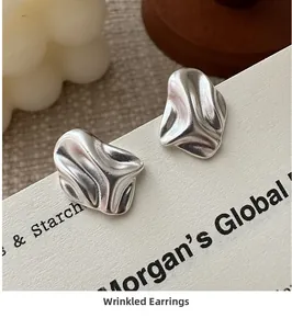 Close-up of S925 sterling silver earrings with unique irregular pleated wavy texture