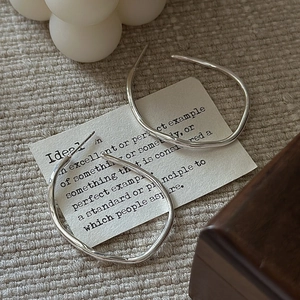Minimalist S925 sterling silver hoop earrings with irregular fluid design on fabric
