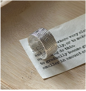 Gros plan d'une bague en argent sterling 925 avec une texture tressée vintage complexe