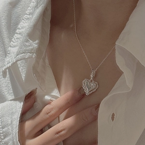 S925 sterling silver wavy heart pendant necklace on model's neck for a minimalist look