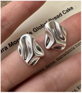 Detailed close-up of S925 sterling silver earrings with irregular wrinkled texture