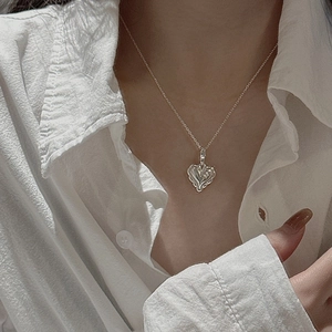 Minimalist S925 sterling silver heart pendant necklace styled on white shirt collar