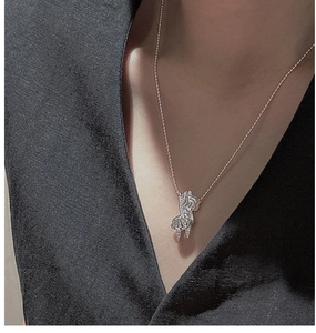 Detail of S925 sterling silver zebra pendant necklace on a dark suit background