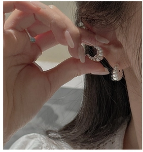 Macro detail of S925 sterling silver croissant earrings with textured matte finish