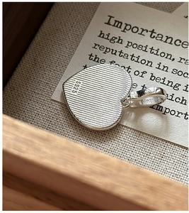 Vue détaillée du pendentif cœur en argent sterling S925 avec texture brossée et poinçon