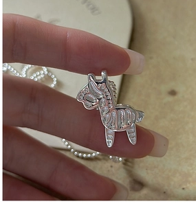 Macro view of a 925 sterling silver rocking horse pendant with detailed engravings