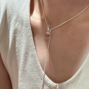 Minimalist S925 silver necklace with transparent crystal ball pendant on a knit sweater