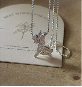 Macro shot of S925 sterling silver carousel pendant on a refined bead chain