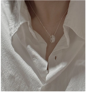 Collier minimaliste en argent S925 avec pendentif cercle porté sur un col de chemise