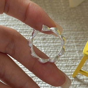 Minimalist S925 sterling silver open ring with scalloped texture on fabric background
