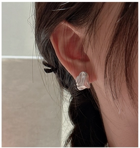 Close-up of S925 sterling silver stud earrings with irregular wave lava texture on model