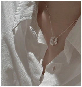 Détail du collier en argent sterling S925 avec pendentif circulaire texturé sur chaîne fine