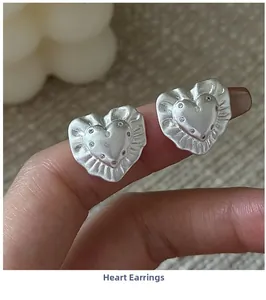 Close-up of S925 sterling silver heart earrings with matte texture and sparkling crystals