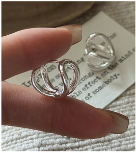 Macro shot of silver S925 sterling silver hoop earrings with twisted curved design